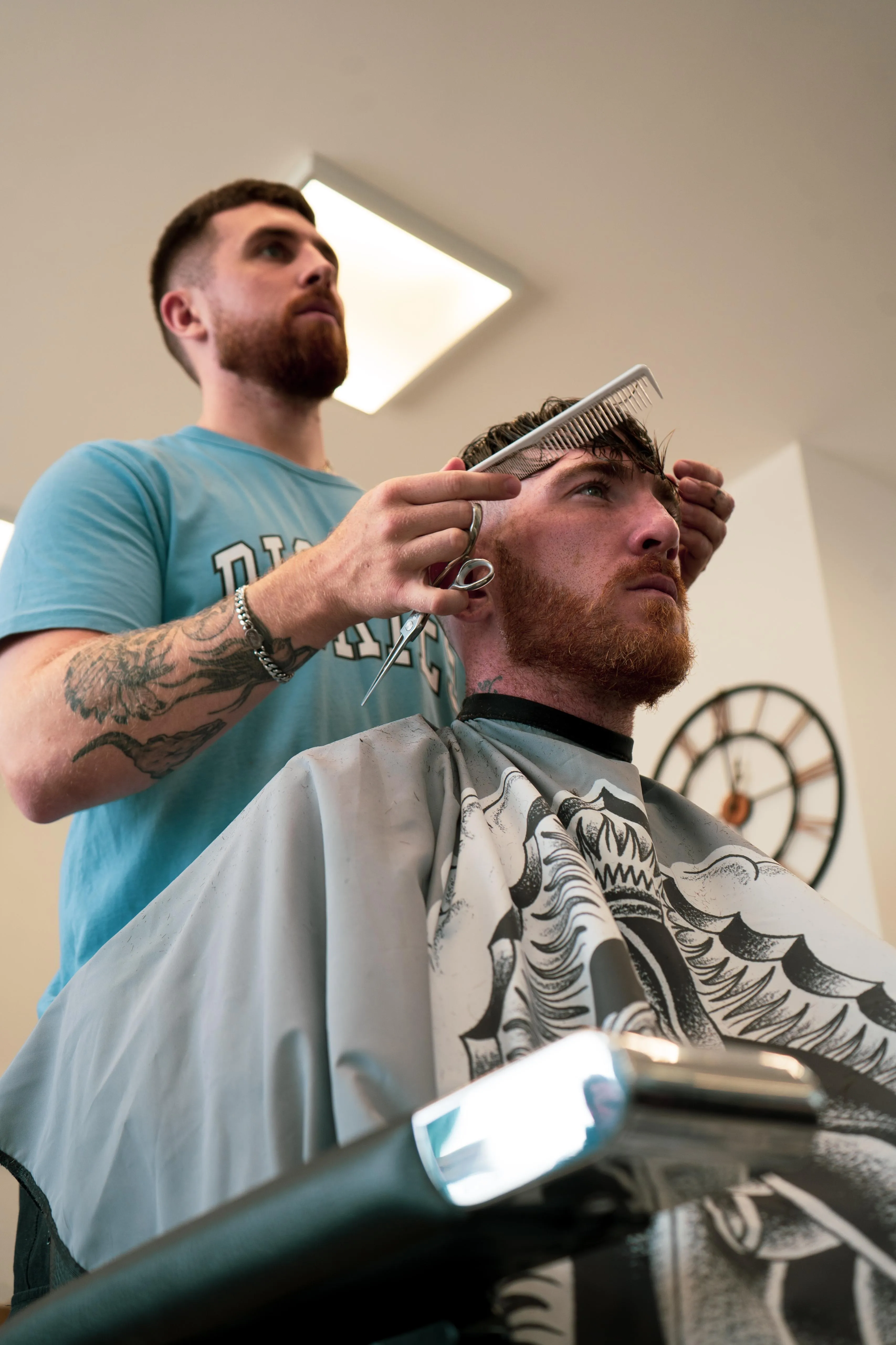 A low-angle scissor-over-comb cut in progress at Barber Lounge